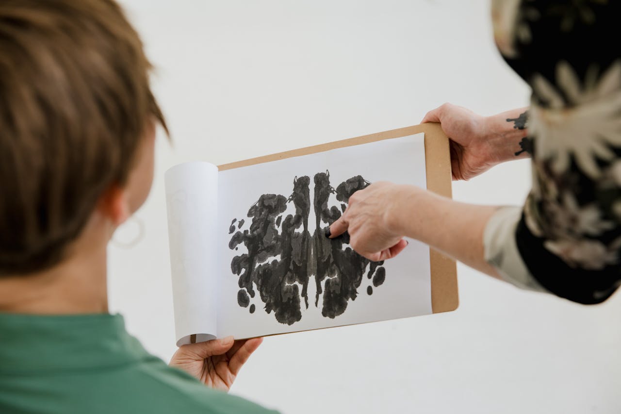 A psychologist and patient discuss a Rorschach inkblot test during a therapy session.
